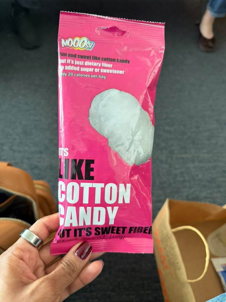 Hand holding pink package of Mooosh! sweet fiber snack shaped like cotton candy